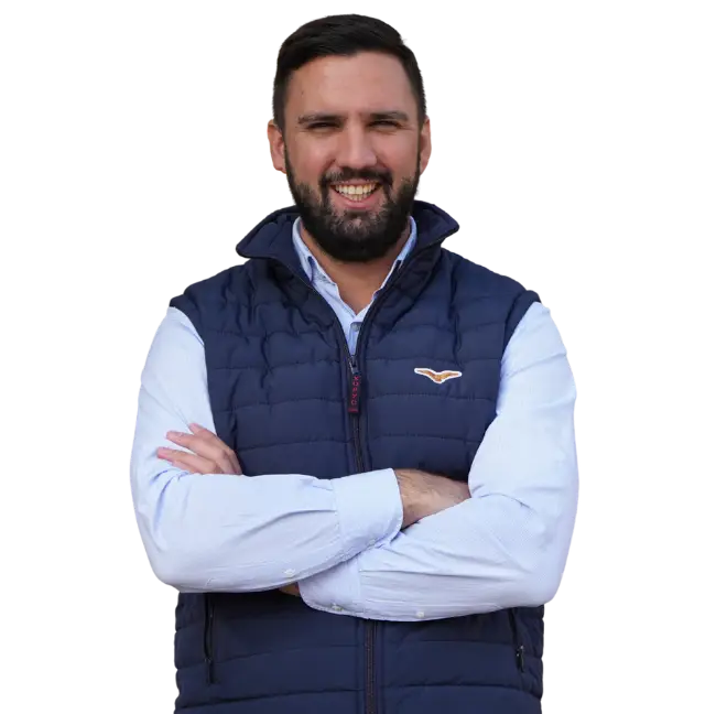 Stefan Simic sa smeškom, prekrštenih ruku, nosi prsluk i košulju.